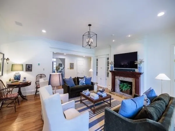 a kitchen with stainless steel appliances granite countertop a stove top oven a sink dishwasher and a dining table with wooden floor