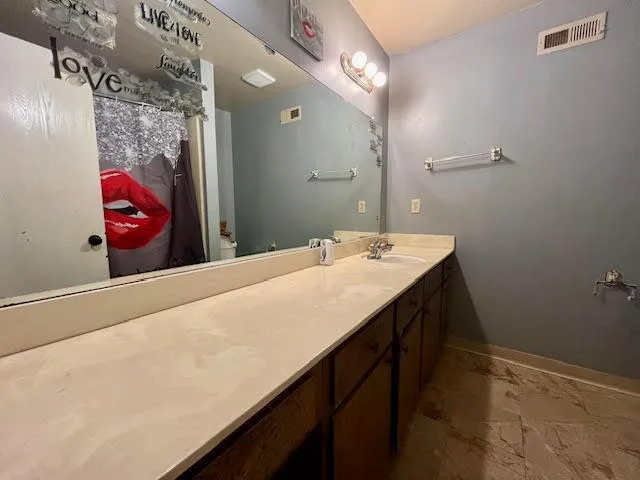 a bathroom with a sink vanity and a mirror