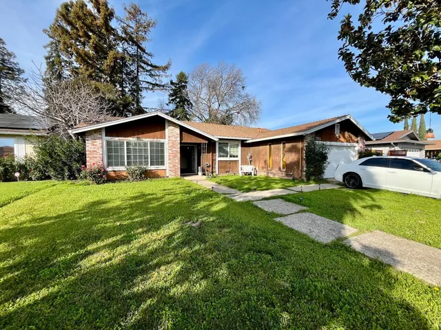 a front view of house with yard and green space