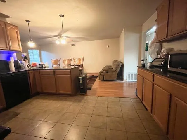 a kitchen with stainless steel appliances a sink a counter top space cabinets and flat screen tv