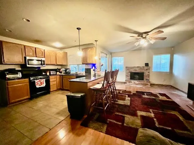 a kitchen with kitchen island granite countertop a sink cabinets and stainless steel appliances