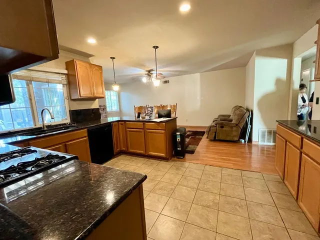 a kitchen with stainless steel appliances granite countertop a sink counter space cabinets and a stove top oven