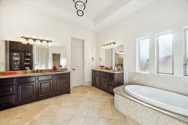 a large bathroom with a tub a double vanity sink and mirror
