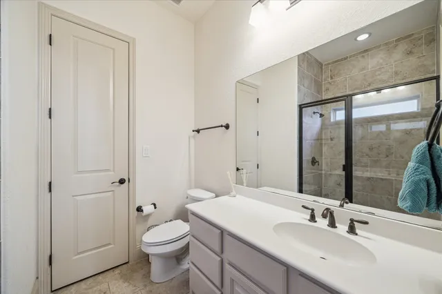 a bathroom with a toilet a sink a mirror and a shower