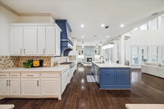 a kitchen with granite countertop a sink cabinets and wooden floor