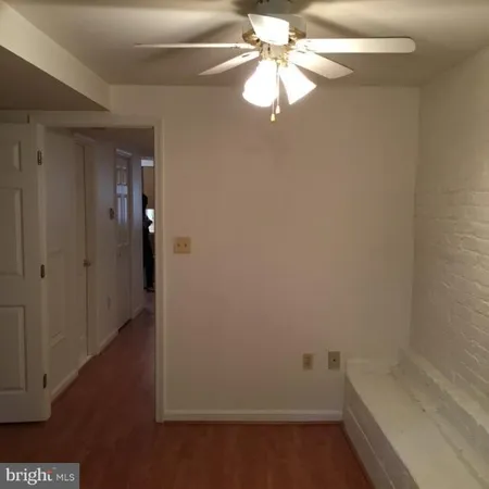 wooden floor in an empty room with a chandelier fan
