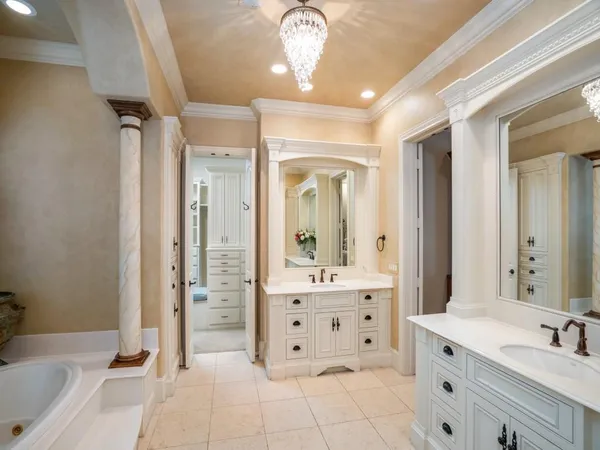 a spacious bathroom with a double vanity sink a mirror a bathtub and a shower