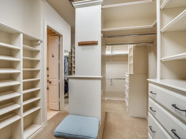 a view of walk in closet with empty racks