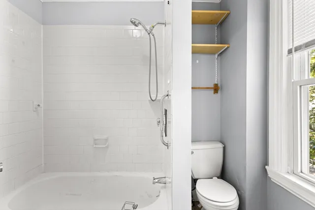 a white toilet sitting next to a bath tub