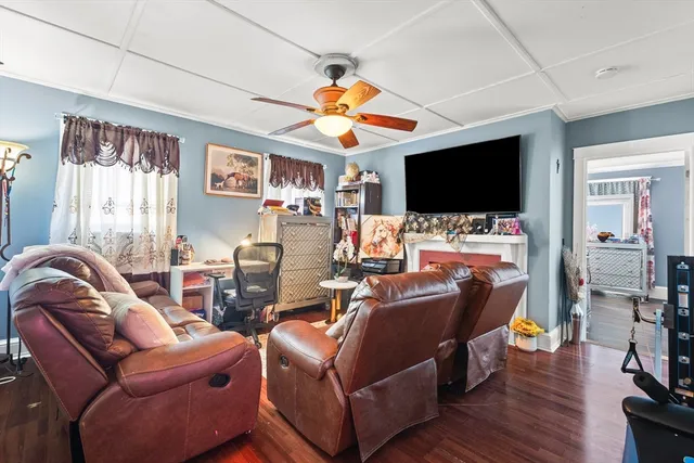 a living room with furniture a flat screen tv and wooden floor