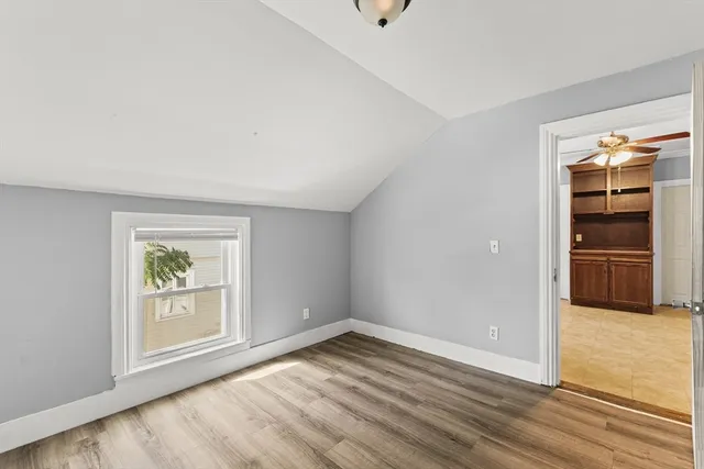 an empty room with window & wooden floor