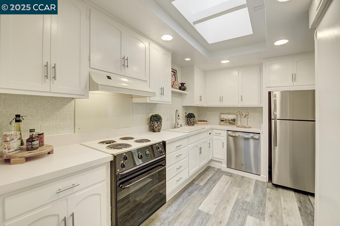 1315 Golden Rain Road, Unit 2 Walnut Creek, CA 94595 - Photo 16 of 54 a kitchen with cabinets appliances and wooden floor