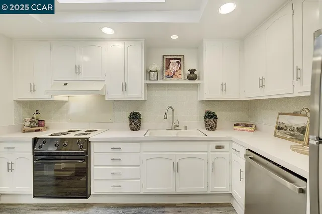 a kitchen with a stove and white cabinets