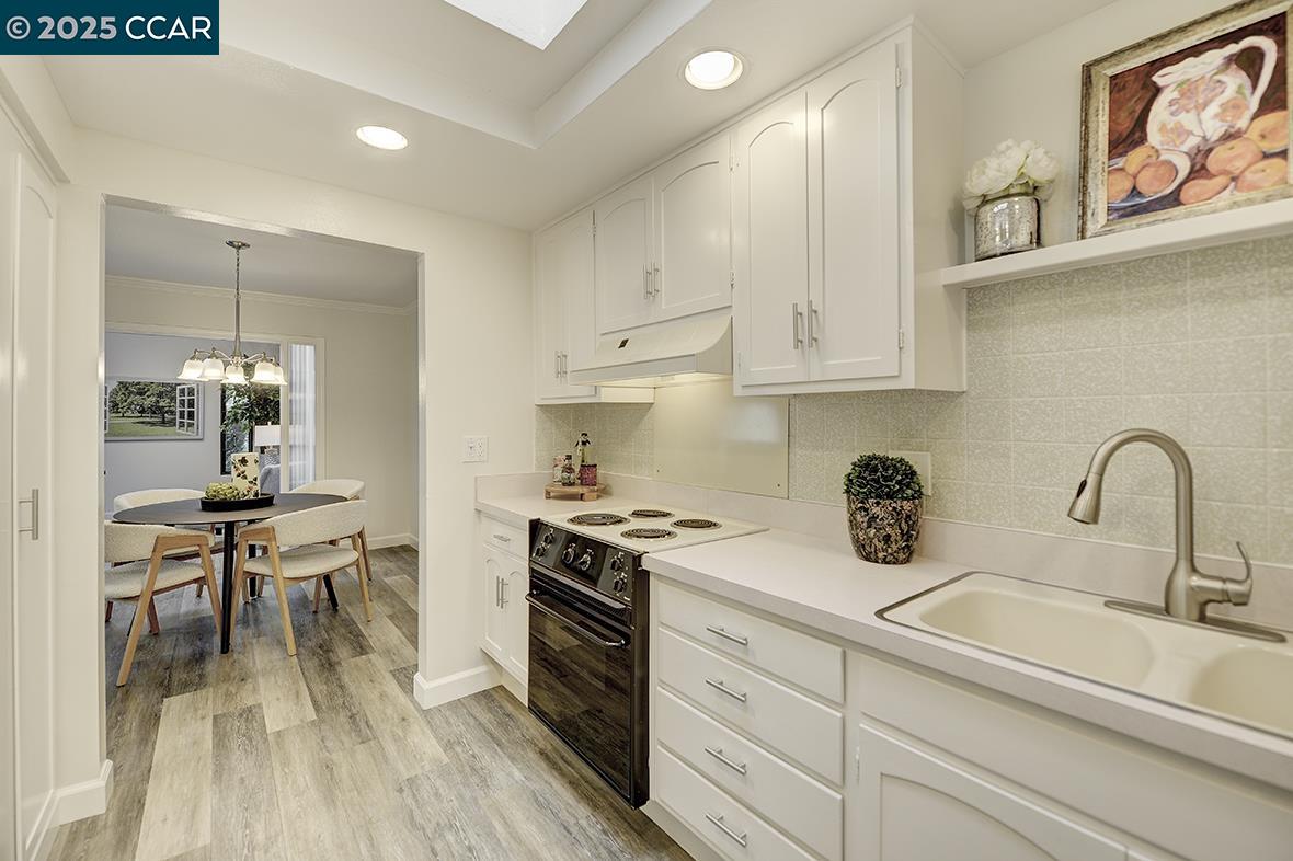 1315 Golden Rain Road, Unit 2 Walnut Creek, CA 94595 - Photo 18 of 54 a kitchen with a stove and white cabinets