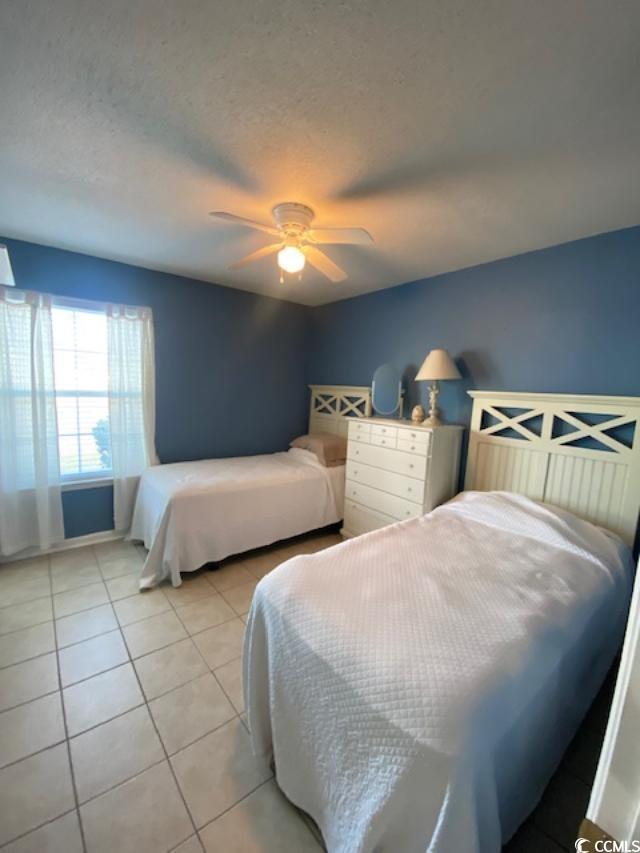 2265 Huntingdon Drive, Unit A Surfside Beach, SC 29575 - Photo 11 of 18 Tiled bedroom featuring ceiling fan and a textured ceiling