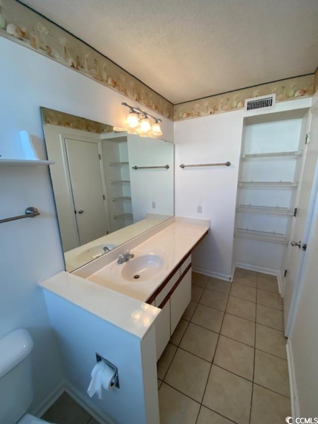 2265 Huntingdon Drive, Unit A Surfside Beach, SC 29575 - Photo 10 of 18 Bathroom featuring vanity, a textured ceiling, tile patterned floors, and toilet