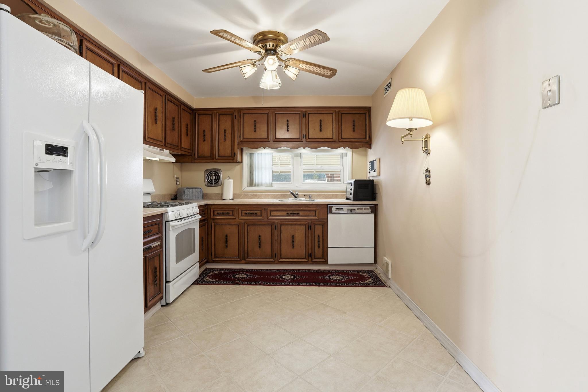 8931 Leonard Street Philadelphia, PA 19152 - Photo 12 of 52 a kitchen with a stove a sink and a refrigerator