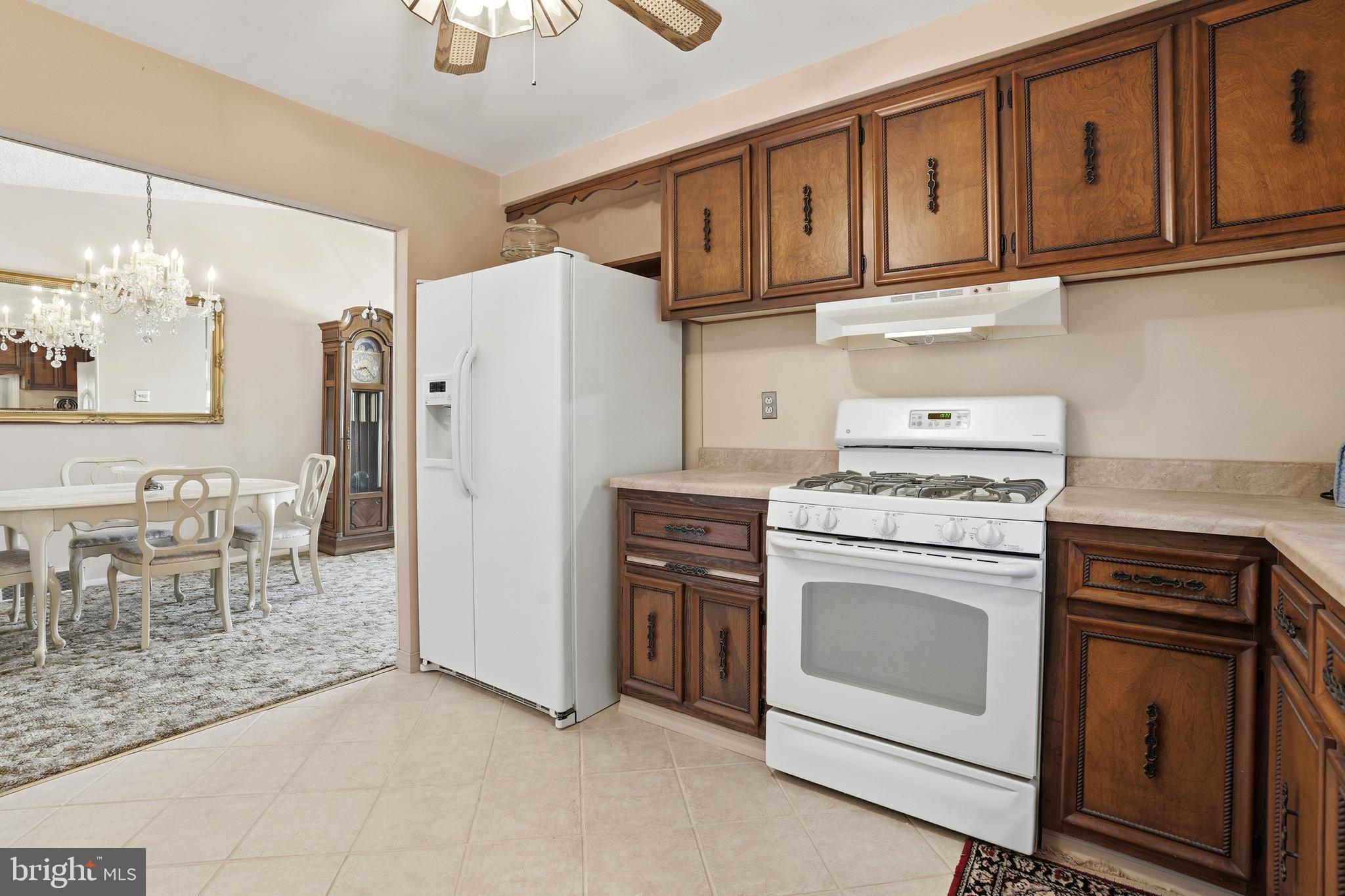 8931 Leonard Street Philadelphia, PA 19152 - Photo 15 of 52 a kitchen with stainless steel appliances granite countertop a stove a refrigerator and a cabinets with wooden floor
