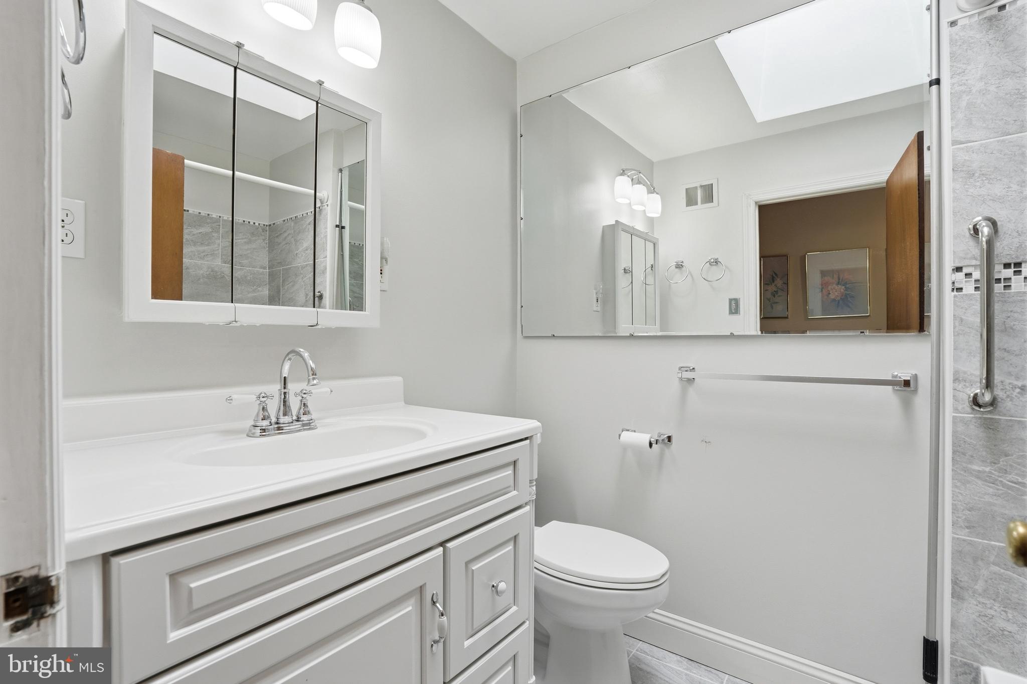 8931 Leonard Street Philadelphia, PA 19152 - Photo 18 of 52 a bathroom with a sink a toilet a mirror and shower