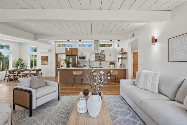 a large white kitchen with stainless steel appliances granite countertop a lot of counter space and wooden floors