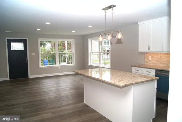 a kitchen with a sink chandelier and wooden floor
