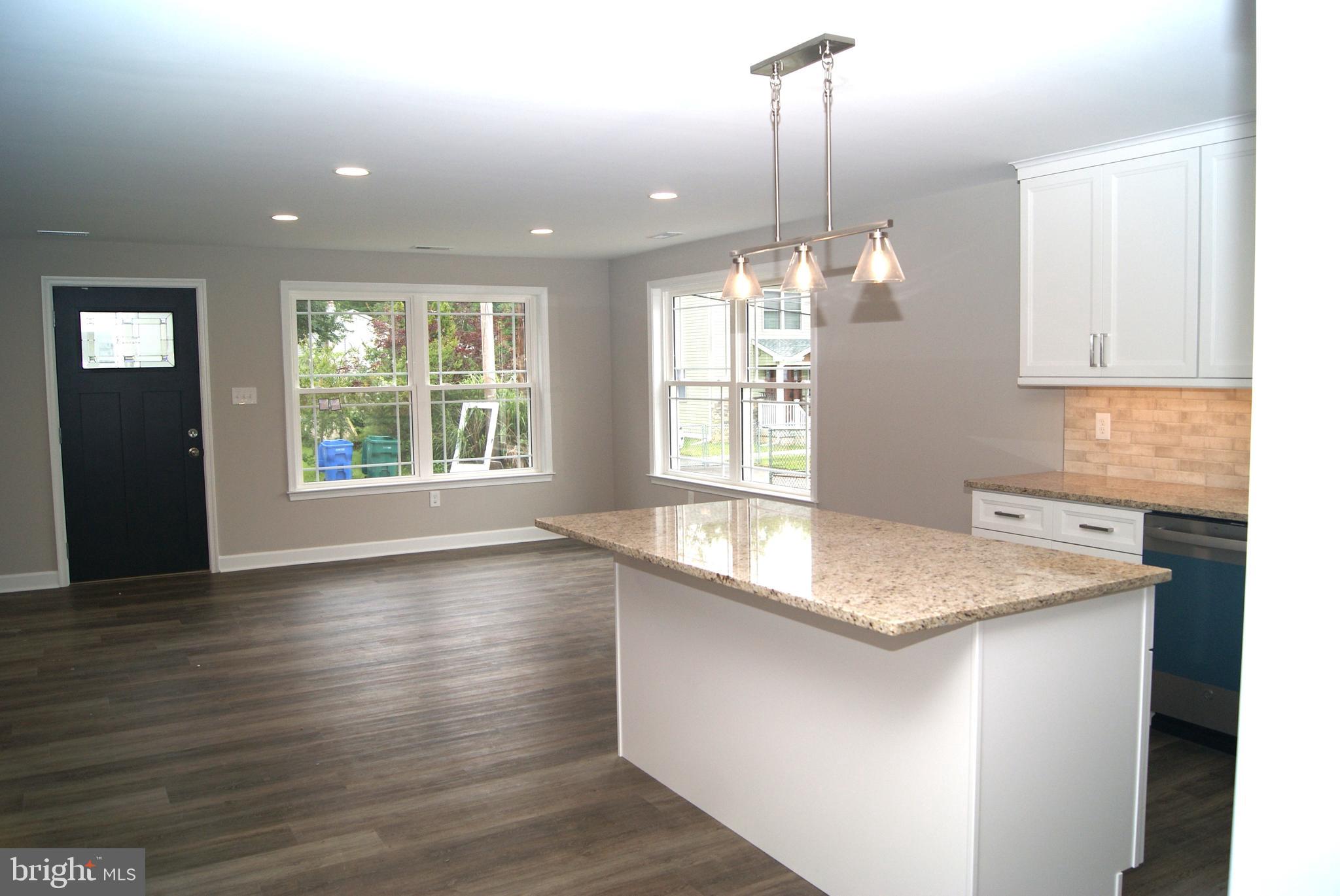 3702 Nichol Street Bristol, PA 19007 - Photo 4 of 7 a kitchen with a sink chandelier and wooden floor