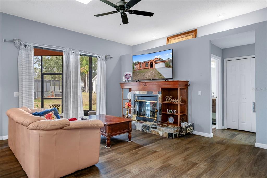 4401 Plumosa Street Spring Hill, FL 34607 - Photo 12 of 38 a living room with furniture and a fireplace