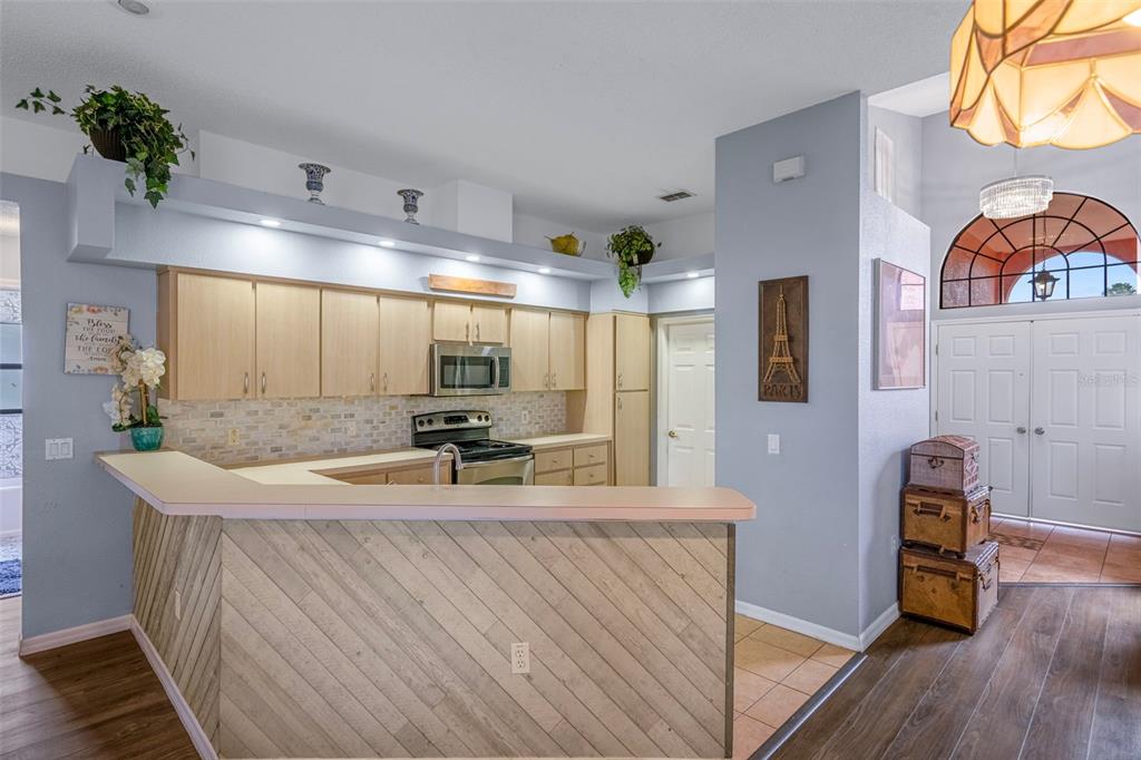 4401 Plumosa Street Spring Hill, FL 34607 - Photo 15 of 38 a kitchen with stainless steel appliances granite countertop a sink a stove and wooden floors
