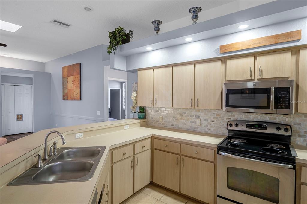 4401 Plumosa Street Spring Hill, FL 34607 - Photo 16 of 38 a kitchen with stainless steel appliances a sink a stove and microwave