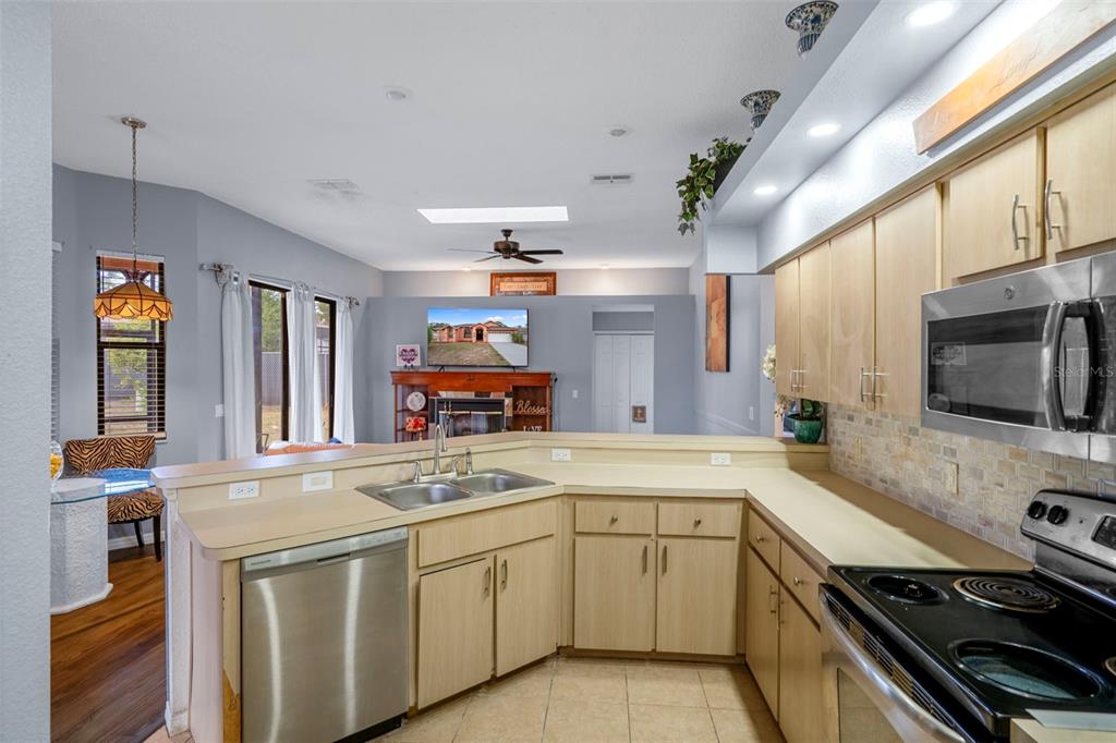 4401 Plumosa Street Spring Hill, FL 34607 - Photo 17 of 38 a kitchen with stainless steel appliances a sink stove and cabinets