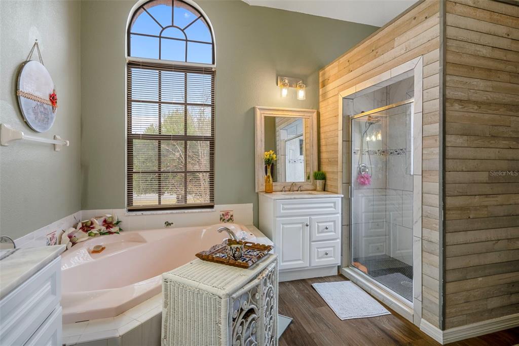 4401 Plumosa Street Spring Hill, FL 34607 - Photo 22 of 38 a bathroom with a sink a mirror and a shower