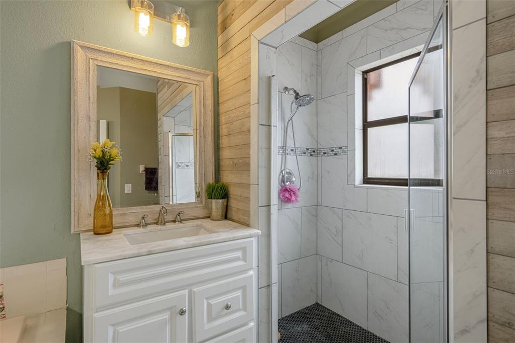 4401 Plumosa Street Spring Hill, FL 34607 - Photo 24 of 38 a bathroom with a granite countertop shower sink and mirror