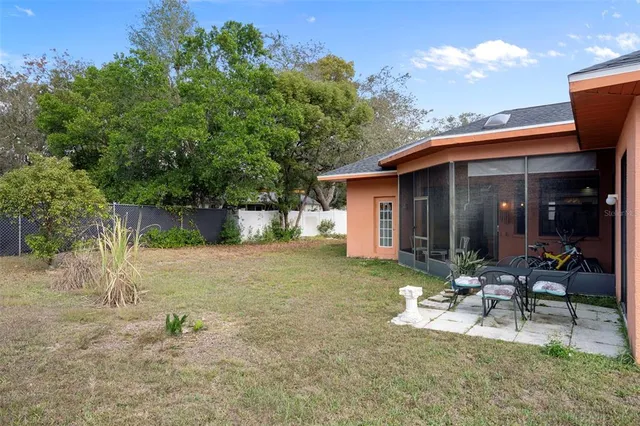 a view of a chair and table in backyard of the house