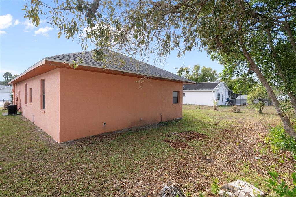 4401 Plumosa Street Spring Hill, FL 34607 - Photo 37 of 38 a backyard of a house with plants and large tree