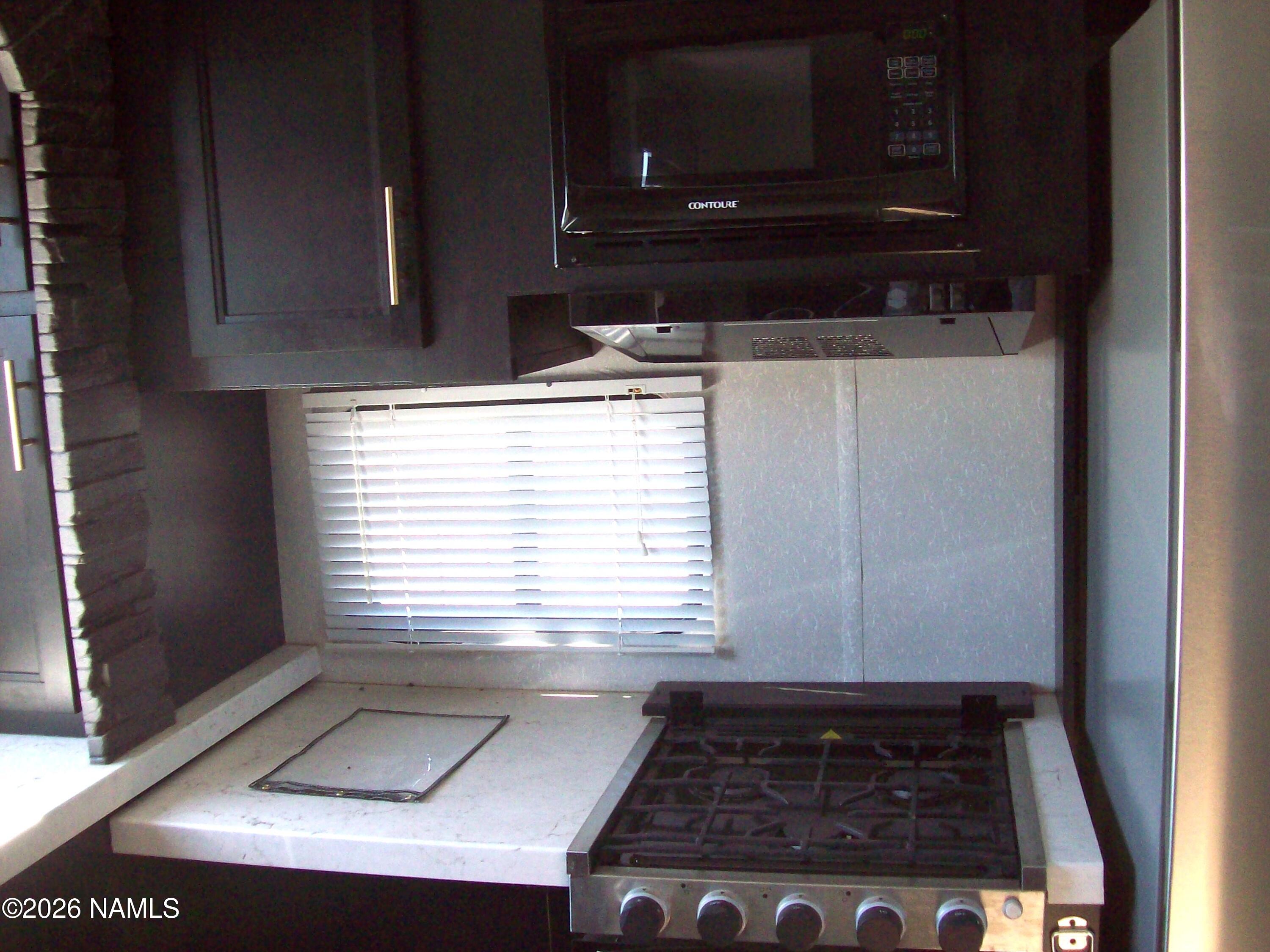 4063 East Woodland Ranch Road Williams, AZ 86046 - Photo 20 of 33 a kitchen with wooden cabinets and a stove top oven