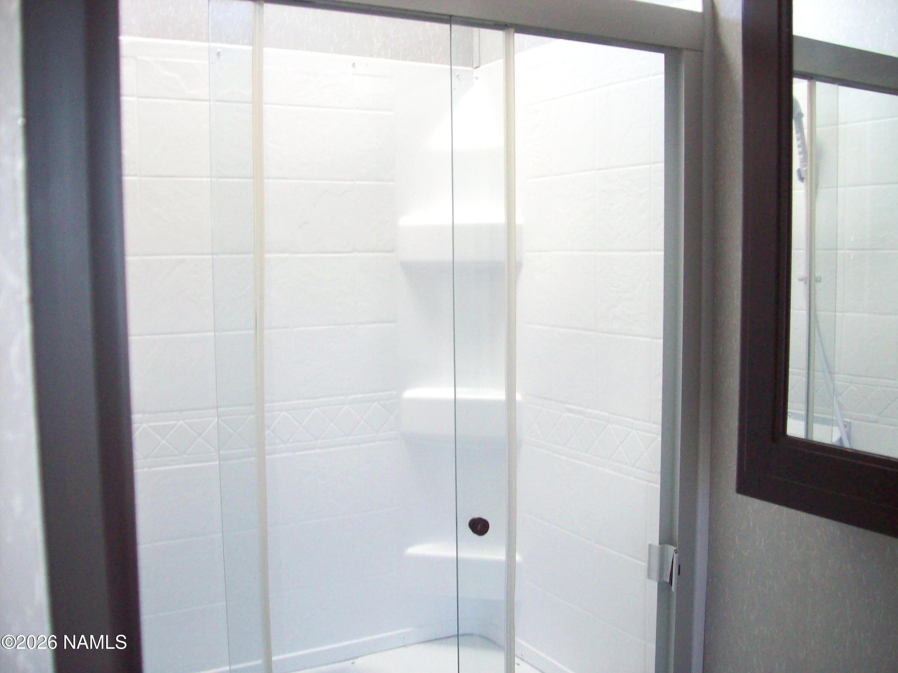 4063 East Woodland Ranch Road Williams, AZ 86046 - Photo 32 of 33 a bathroom with a glass shower door