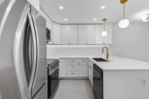 a kitchen with stainless steel appliances a refrigerator sink and cabinets