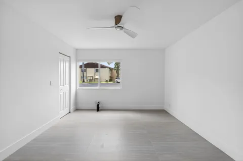 an empty room with windows and cabinet