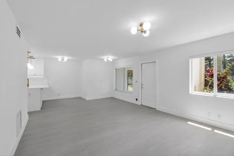 a view of a big room with windows and chandelier fan
