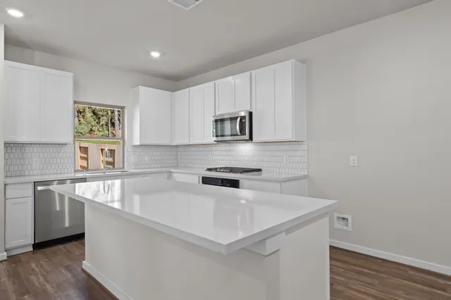 a kitchen with stainless steel appliances a sink a stove and a refrigerator