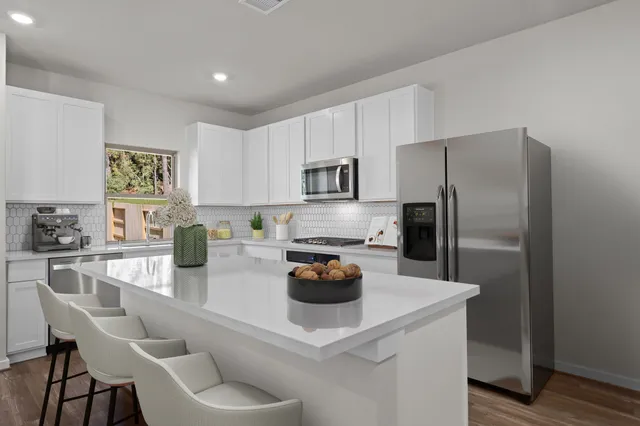 a kitchen with a refrigerator and a stove top oven