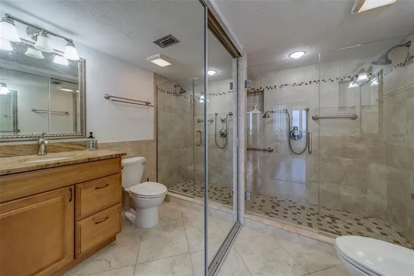 a bathroom with a granite countertop sink toilet and shower