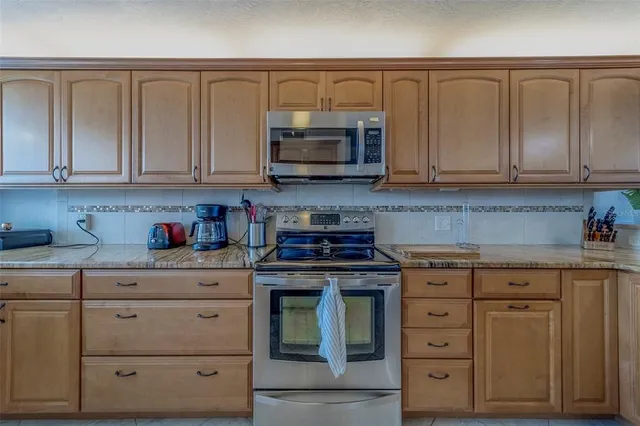 a kitchen with white cabinets and a stove with a sink
