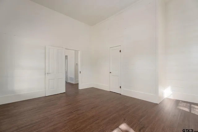 a view of an empty room with wooden floor