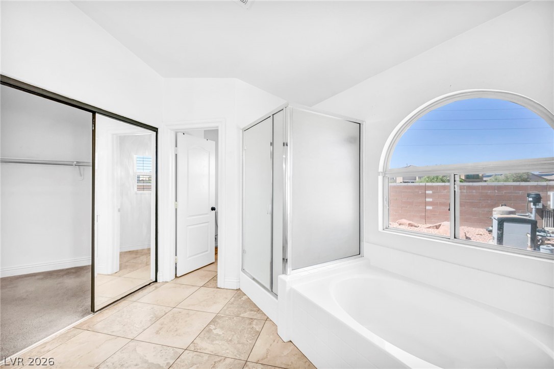 6405 North Raptor Court North Las Vegas, NV 89084 - Photo 34 of 66 Indulge in a tranquil retreat with a deep soaking tub and an arched window inviting natural light.