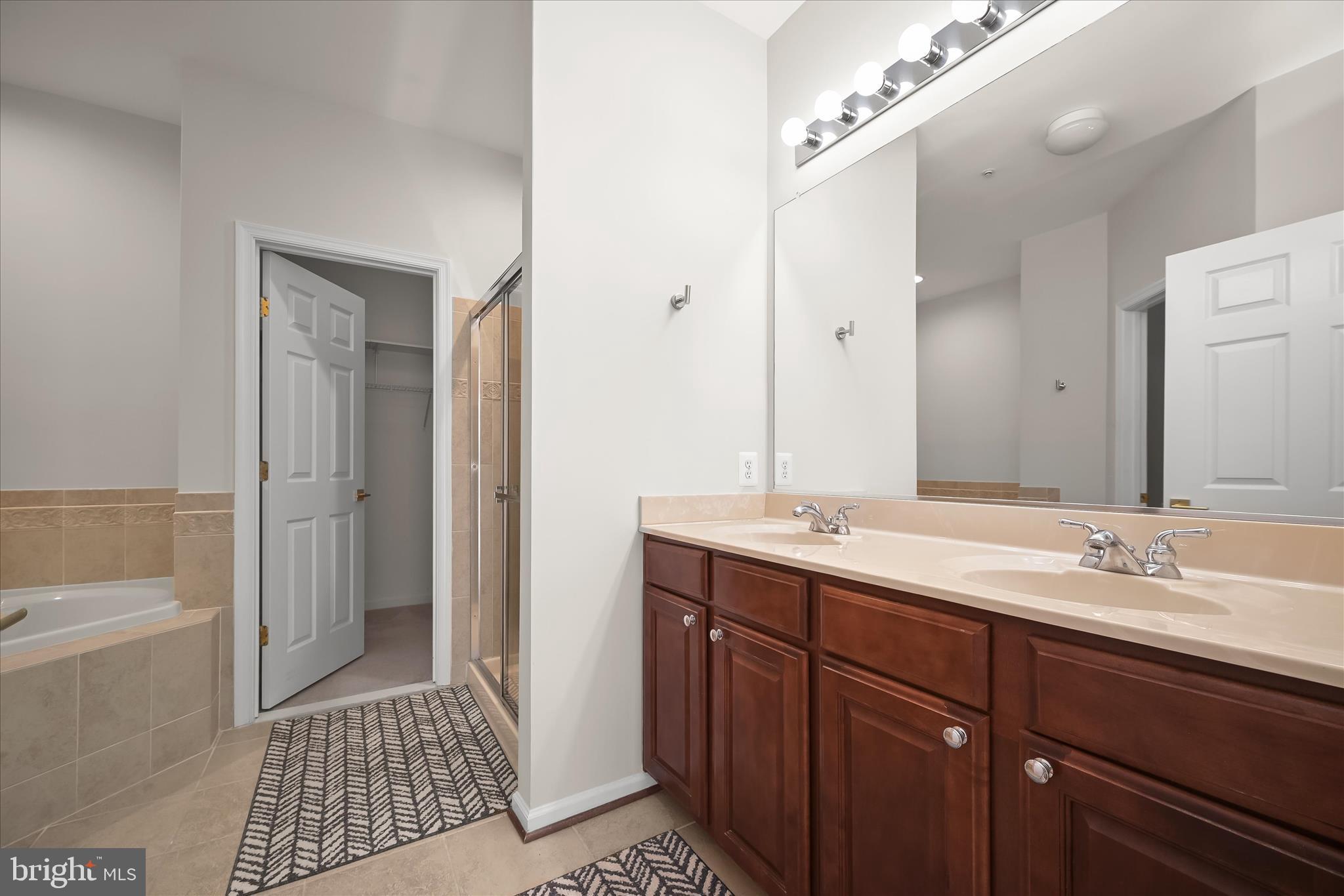 8736 Endless Ocean Way, Unit 24 Columbia, MD 21045 - Photo 23 of 61 a spacious bathroom with a shower a sink and a mirror