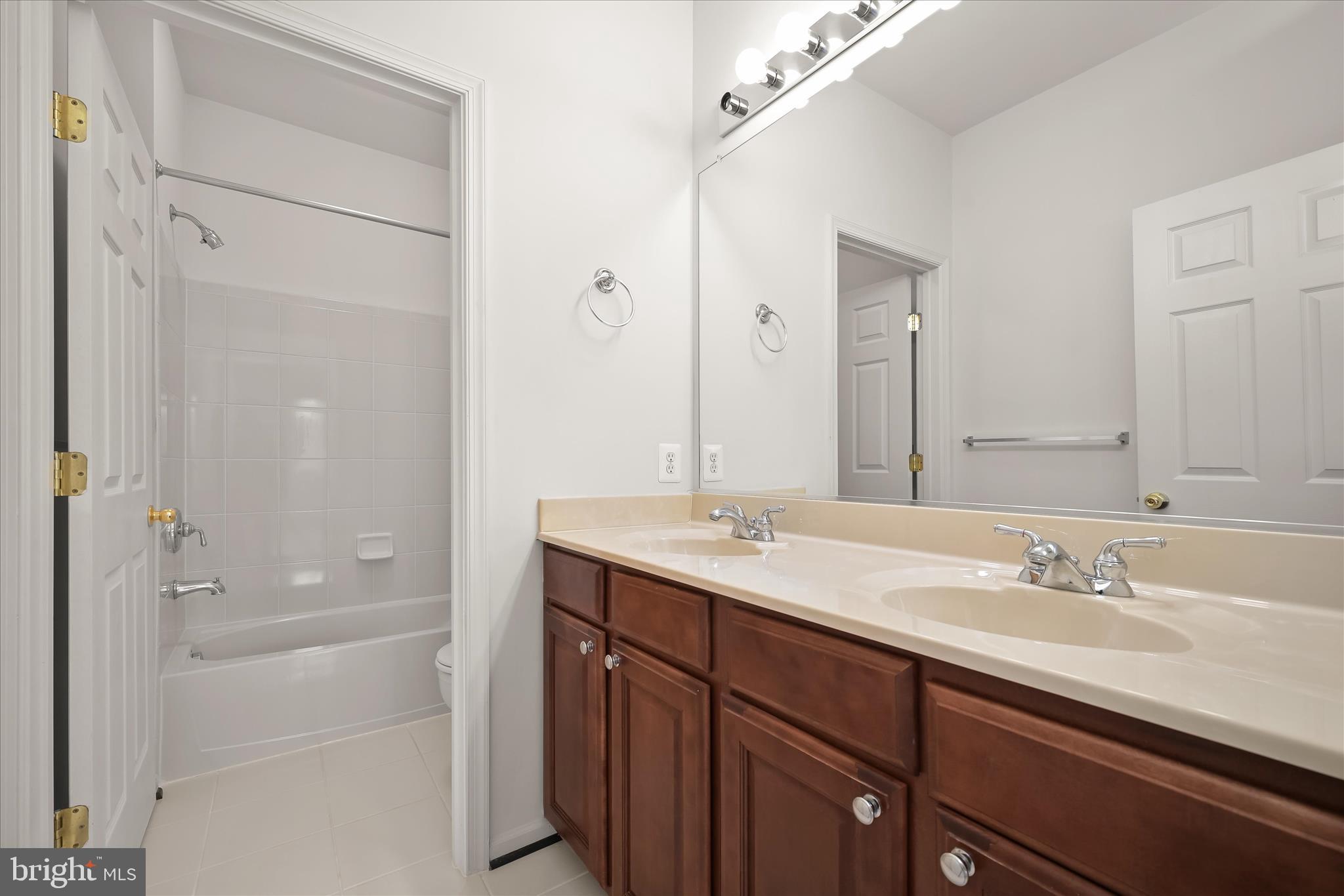 8736 Endless Ocean Way, Unit 24 Columbia, MD 21045 - Photo 35 of 61 a bathroom with a shower sink vanity and mirror