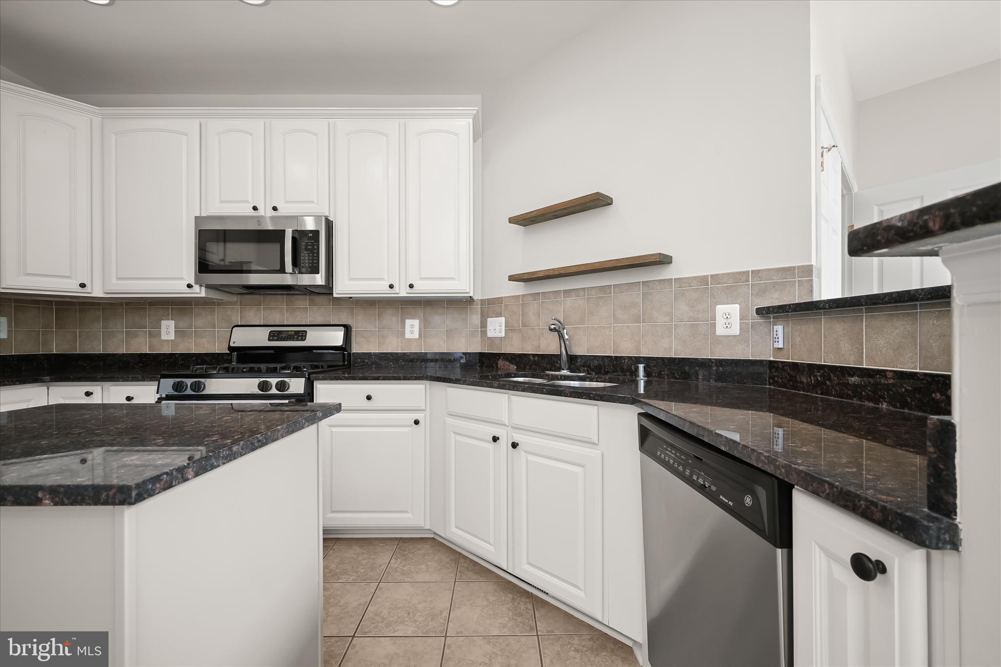 8736 Endless Ocean Way, Unit 24 Columbia, MD 21045 - Photo 8 of 61 a kitchen with granite countertop white cabinets and stainless steel appliances