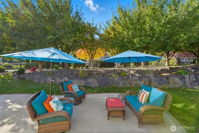 a view of a backyard with table and chairs under an umbrella