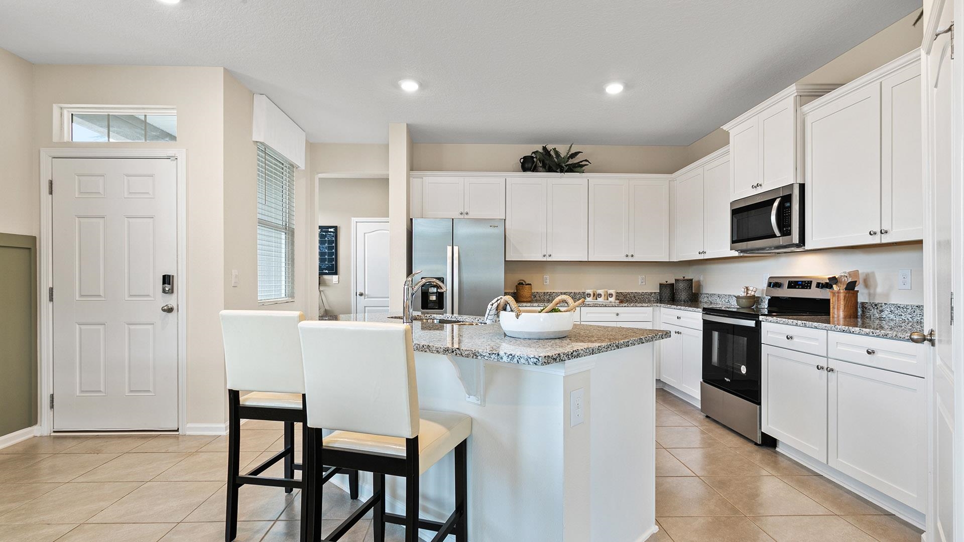 235 Redbud Road Palm Coast, FL 32137 - Photo 8 of 39 a kitchen with white cabinets and stainless steel appliances